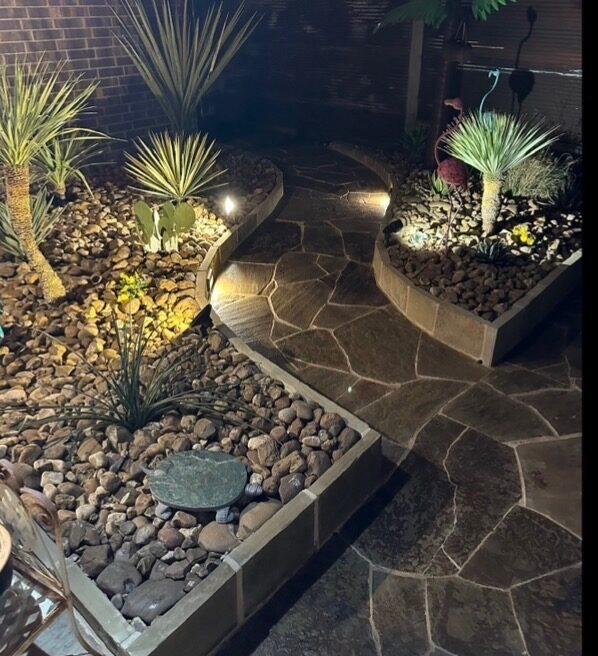 Flagstone patio with landscape uplighting at dusk
