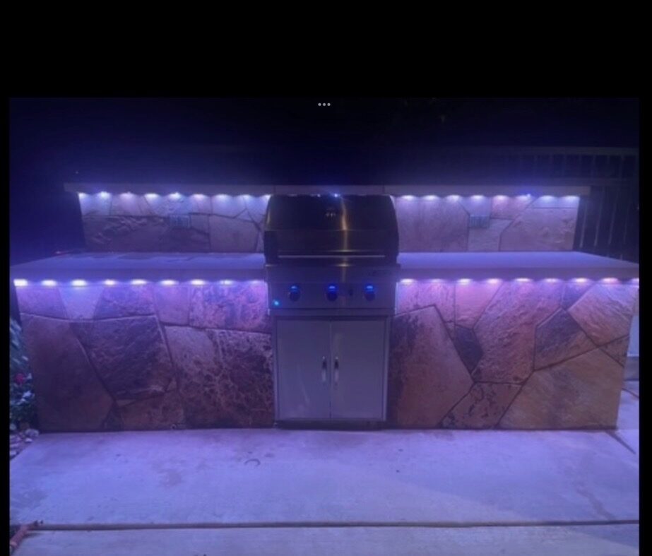 Built-in outdoor kitchen and grill with stone surround