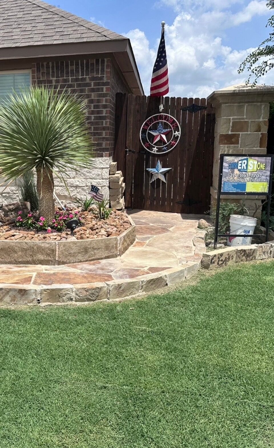 Stone-bordered flower bed with palm and desert plants