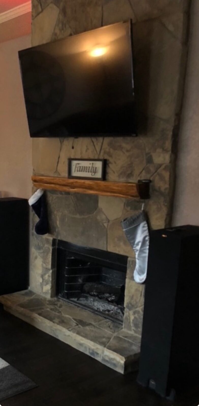TV mounted above a custom stone fireplace